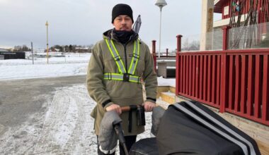 Torbjørn Fredagsvik står med en barnevogn i snøen, iført grønn jakke med reflekser. Bakgrunnen viser en bygning og trær. Det er overskyet vær, og snø dekker bakken. Området ser ut til å være en offentlig plass.
