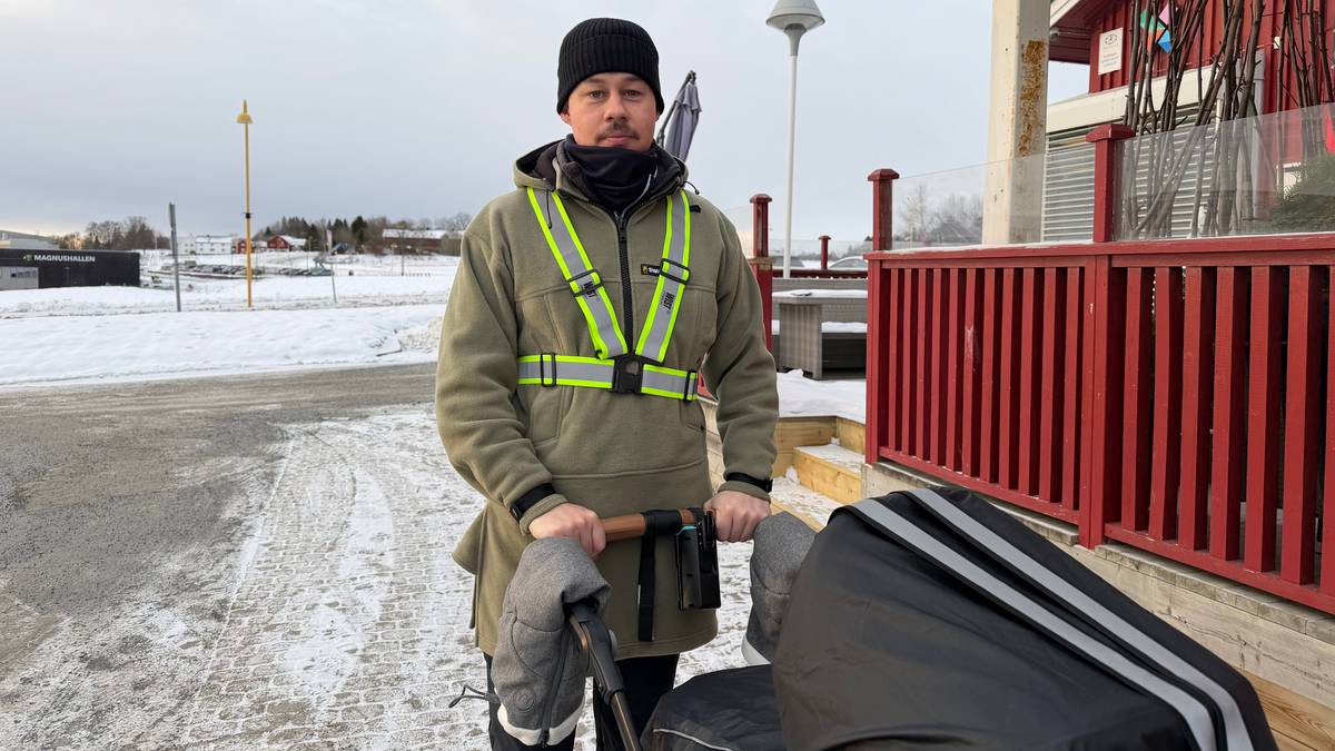 Torbjørn Fredagsvik står med en barnevogn i snøen, iført grønn jakke med reflekser. Bakgrunnen viser en bygning og trær. Det er overskyet vær, og snø dekker bakken. Området ser ut til å være en offentlig plass.