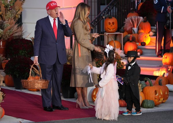 President Donald Trump, from left, and first lady Melania Trump hand candy to children dressed the Tooth Fairy and Abraham Lincoln during a Halloween event on the South Lawn of the White House, Thursday, Oct. 30, 2025, in Washington. (AP Photo/Jacquelyn Martin)