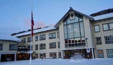 Bygningen Lyngstunet Helse- og Omsorgssenter er dekket av snø. Flagget heises på halv stang foran bygget.