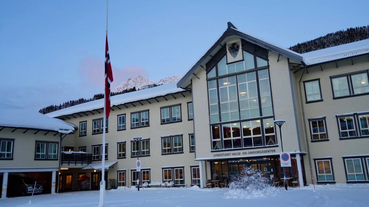 Bygningen Lyngstunet Helse- og Omsorgssenter er dekket av snø. Flagget heises på halv stang foran bygget.