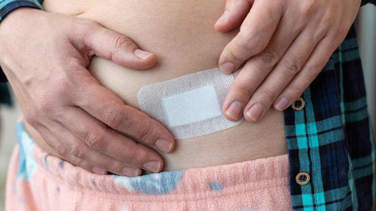 En person som holder på et hormonplaster.