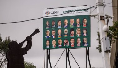 Ein stor plakat viser ansikta til statsleiarane til dei 19 landa som er medlem av G20.