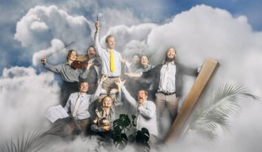 Flere personer som står sammen med himmel og skyer i bakgrunnen.