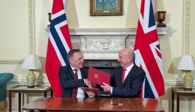 Nores og Storbritannias forsvarsministre tar hverandre i hendene etter avtalesignering.
