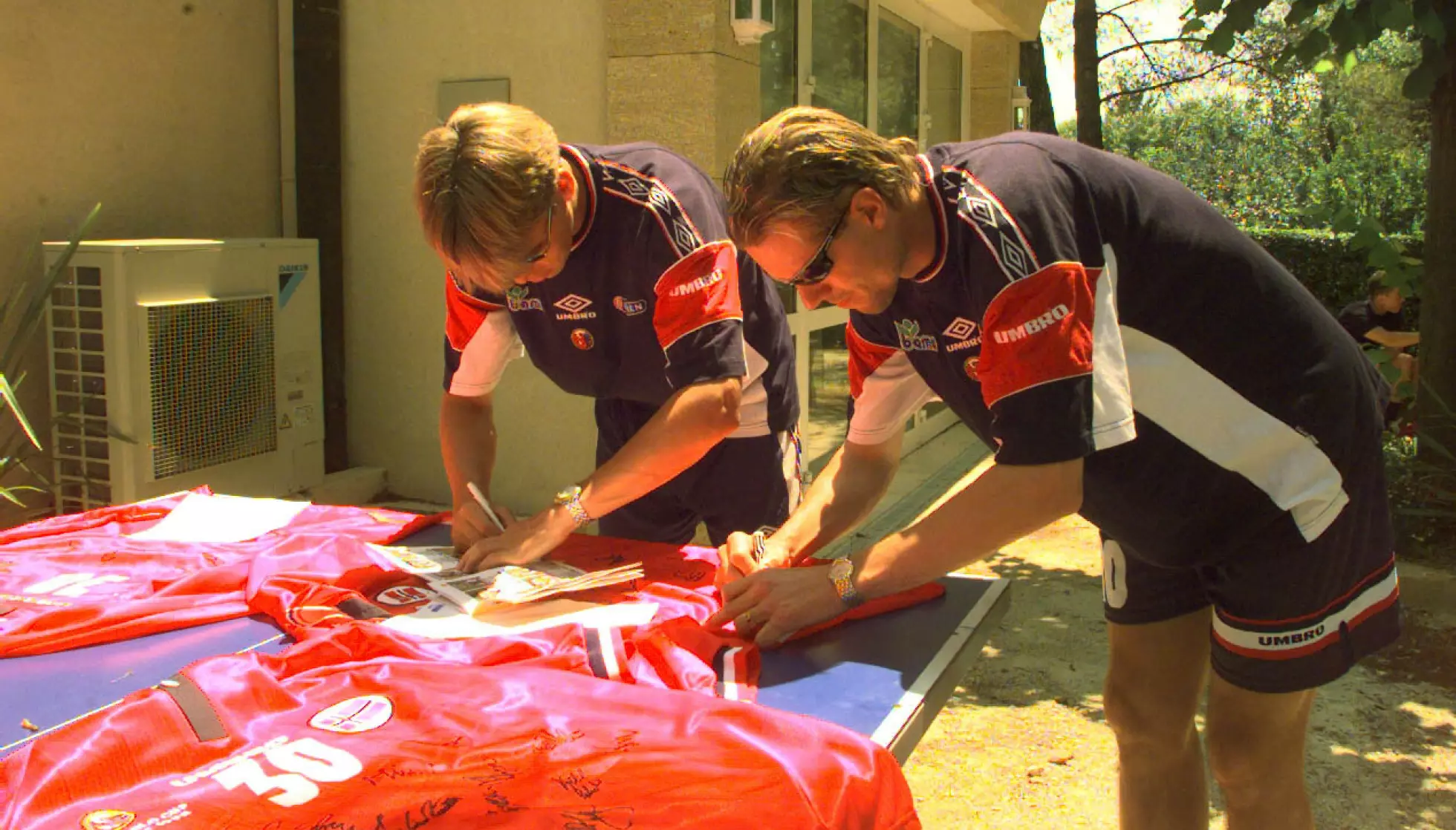 AUTOGRAFER: Gunnar Halle og Kjetil Rekdal travelt opptatt med å signere T-skjorter utenfor hotellet sitt i Provence under VM i 98. Foto Bjørn Sigurdsøn, NTB