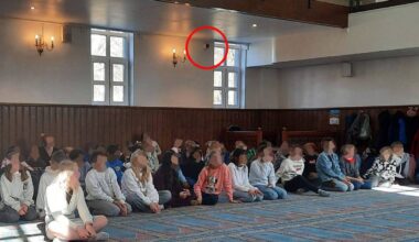 en gruppe mennesker som sitter i et rom