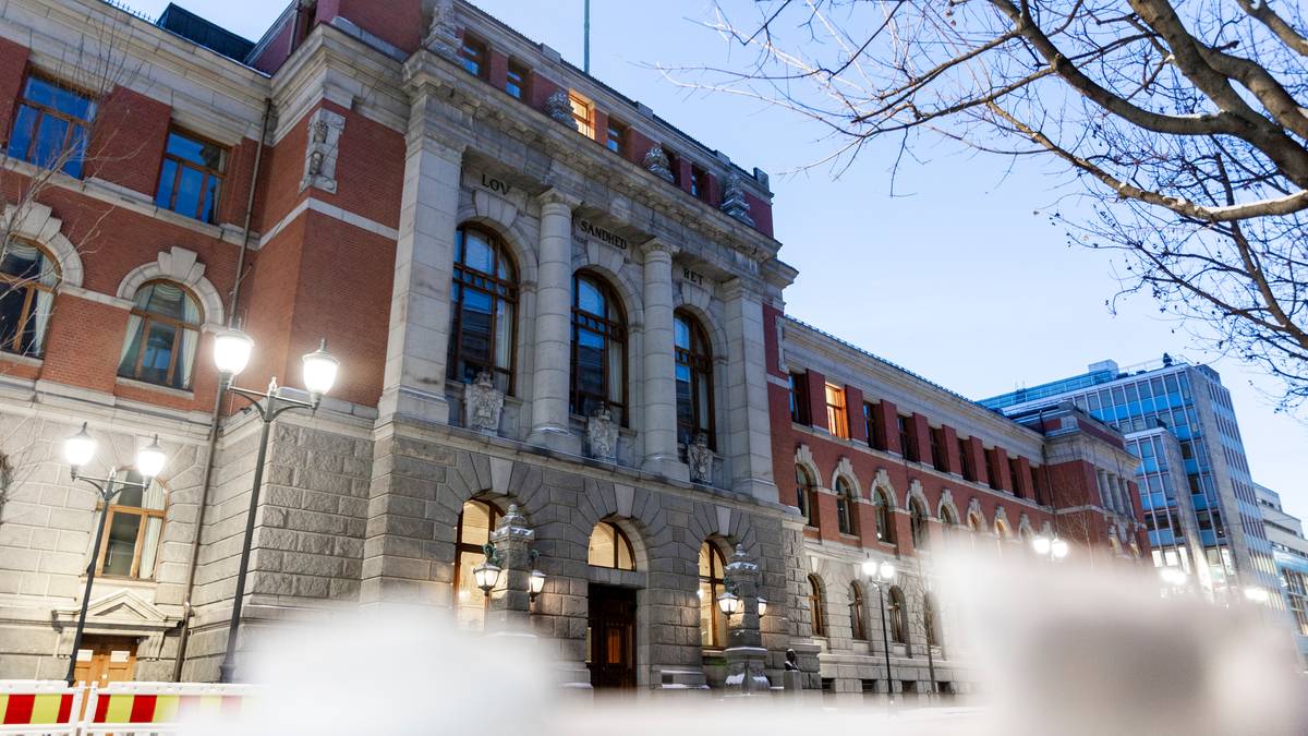 Bygningen av bildet er en historisk struktur med detaljer i nyrenessansestil, beliggende i en urban setting. Det er synlige gatelys og trær i forgrunnen, og himmelen er farget i blå nyanser som signaliserer skumring. Det er også sikkerhetsbarrierer i området, muligens som følge av pågående arbeid eller arrangementer. Bygningens fasade viser detaljer som er typiske for tidsepoken. (Bildebeskrivelsen er laget av en KI-tjeneste)