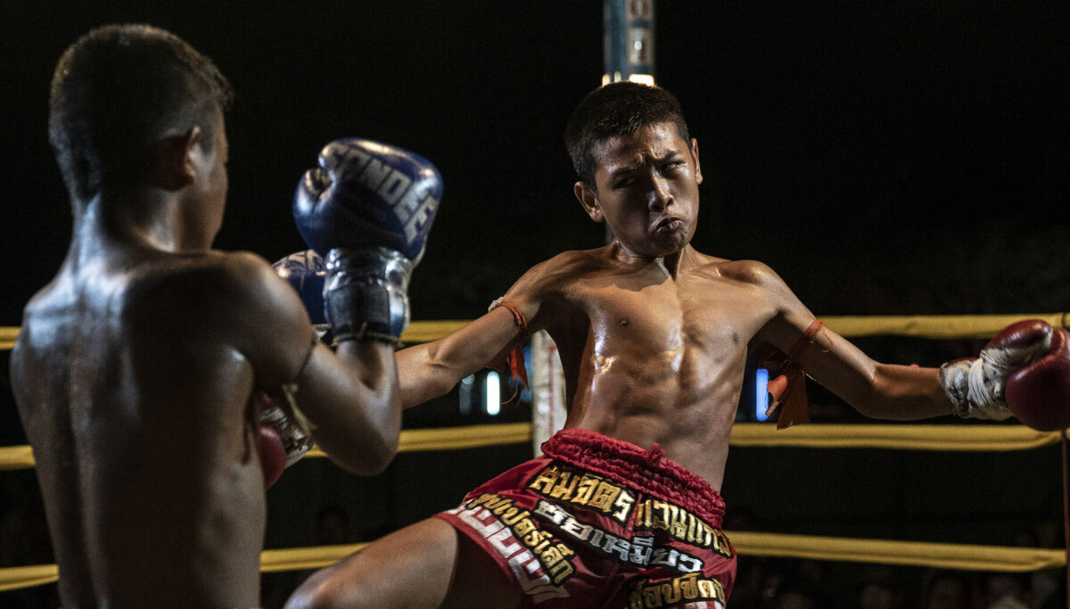 Thailandske barn bokser for livet mens turistene drikker øl og ser på.