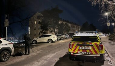 En politibil står parkert ved en kriminalteknikker i en gate om kvelden, i Oslo.
