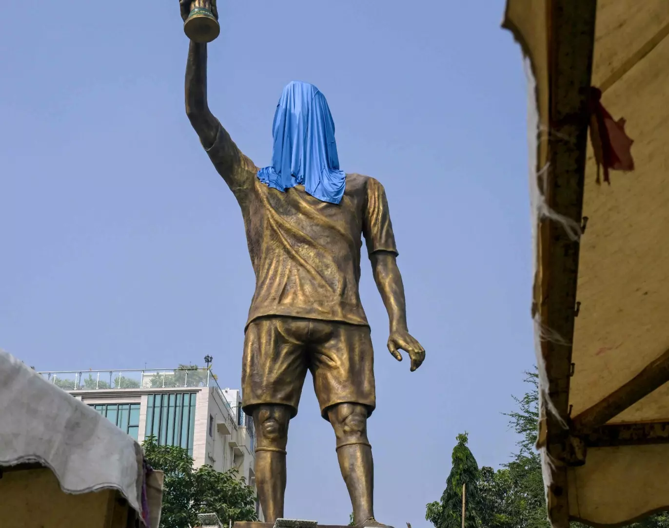 HOLDER VM-TROFEET: Statuen viser Messi som holder VM-trofeet. Her fra før avdukingen. Foto: AFP