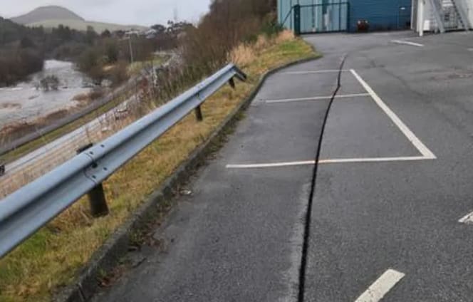 Disse sprekkene skaper bekymring for jordras og fører til at E39 blir stengt. Hovedveien ses nedere til venstre i bildet.