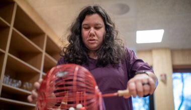 En kvinne med brunt hår som spinner en boks med bingokuler