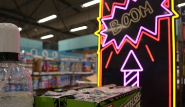 et skilt med en rakett og ordet boom. fremfor står fyrvekeri i kasser