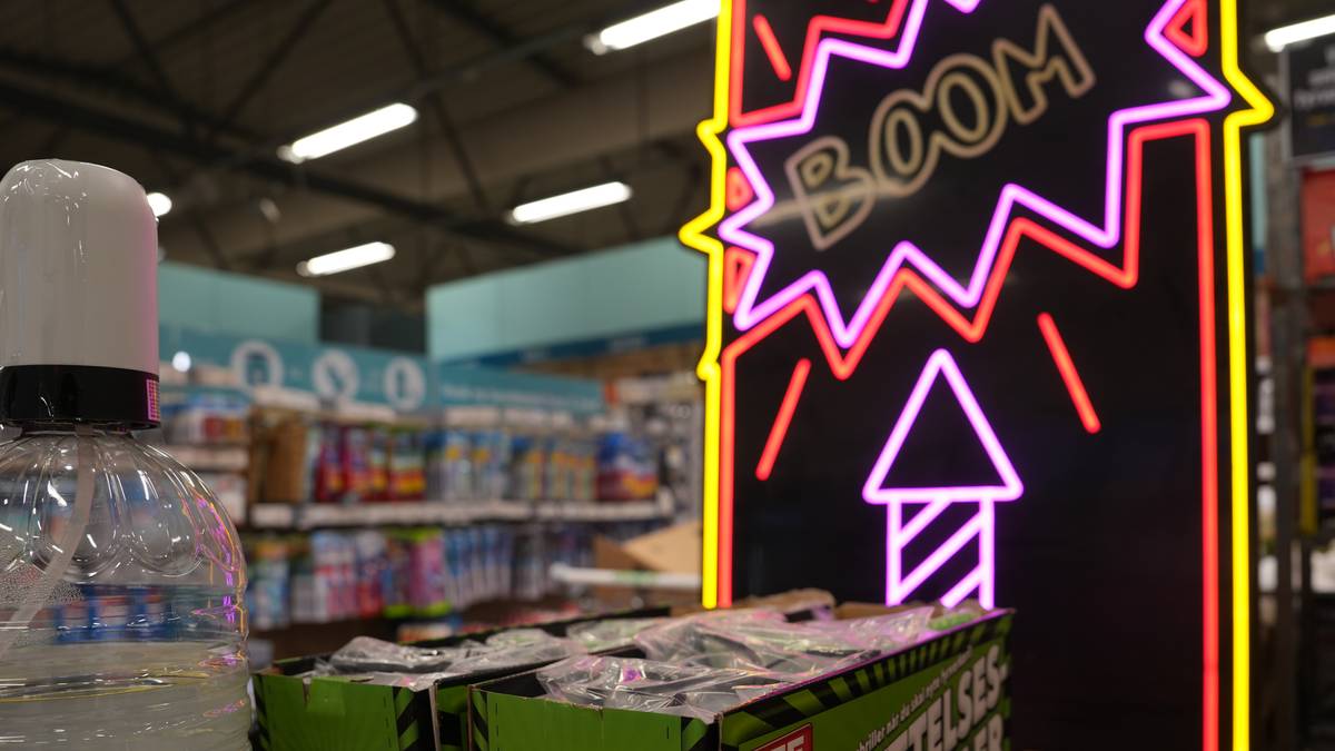 et skilt med en rakett og ordet boom. fremfor står fyrvekeri i kasser