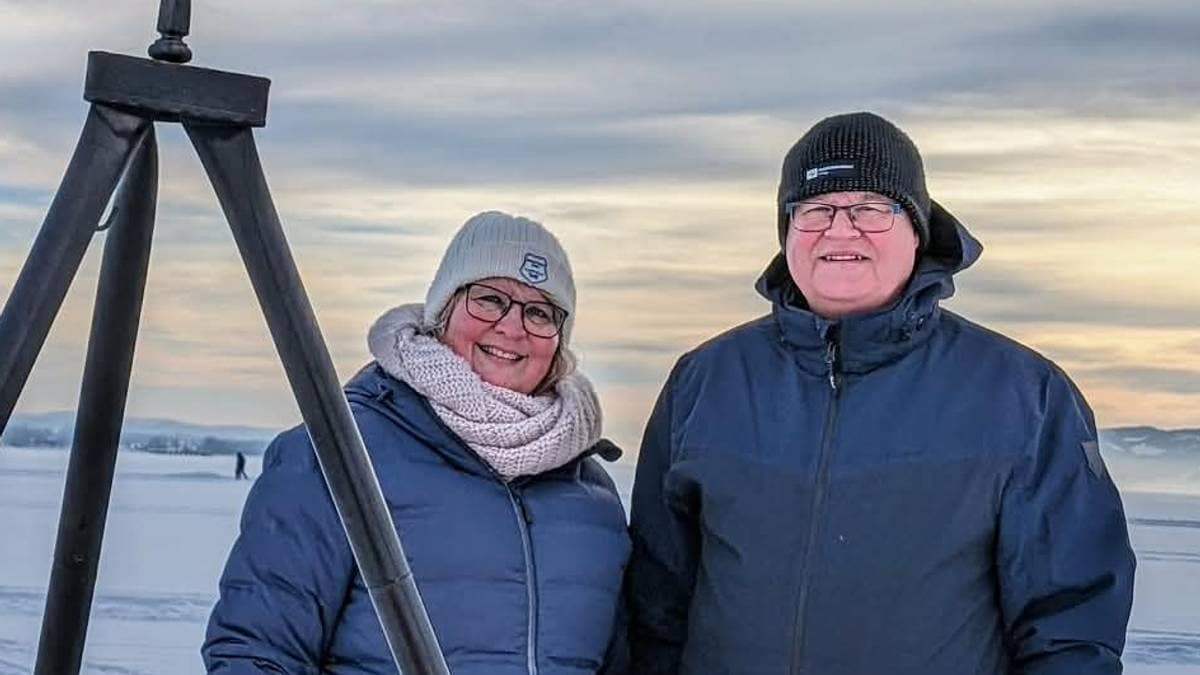 to personer ved en bålpnne. det er vinter