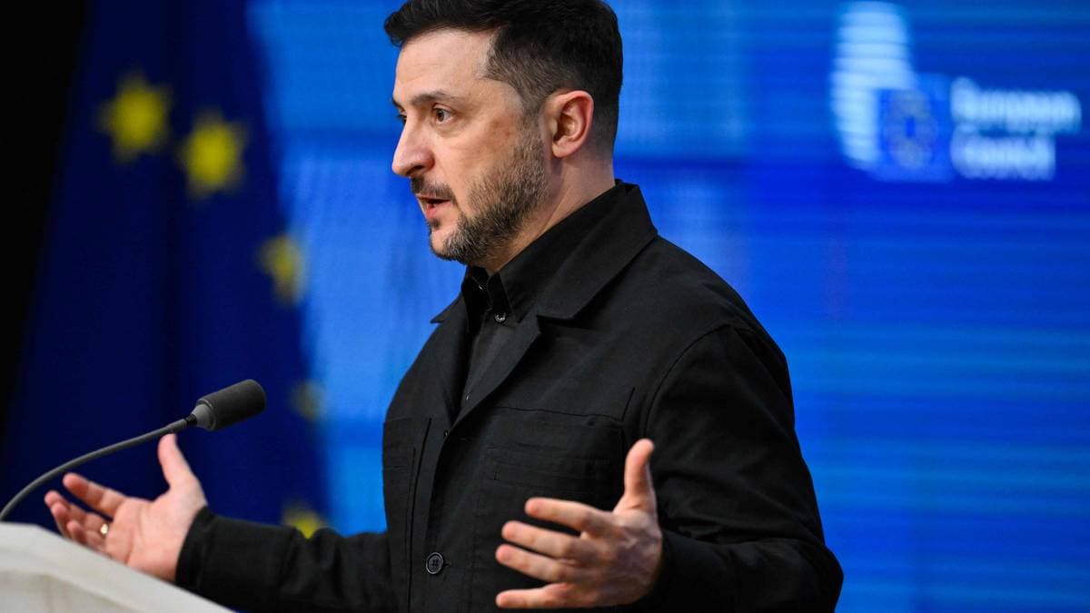 En person står ved et podium, gestikulerer mens de taler. Bakgrunnen viser EU-flagget sammen med grafiske elementer. Det er en pressesituasjon, med fokus på kommunikasjon og informasjon. Atmosfæren er formell og profesjonell. (Bildebeskrivelsen er laget av en KI-tjeneste)