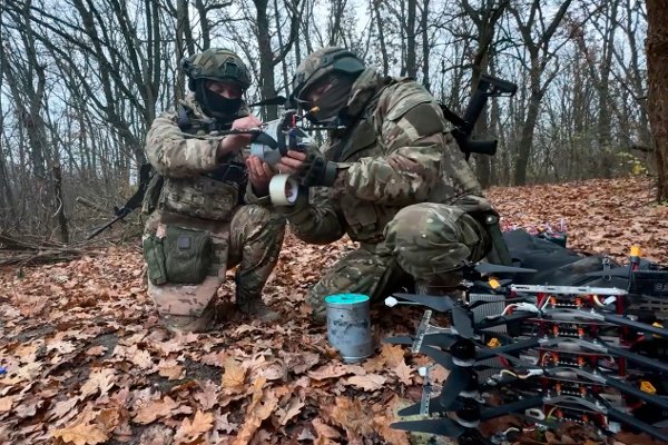 In this photo taken from a video provided by Russian Defense Ministry Press Service on Friday, Nov. 28, 2025, Russian servicemen attach explosives to a drone in an undisclosed location in Ukraine. (Russian Defense Ministry Press Service via AP)