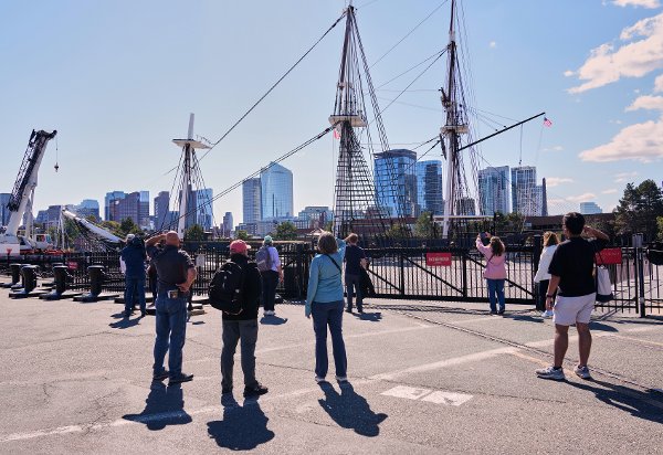 Visitors stand outside the gate of the U.S.S. Constitution, the U.S. Navy's oldest active-duty, commissioned warship, which was closed due to the government shutdown, Wednesday, Oct. 1, 2025, in Boston. (AP Photo/Charles Krupa)