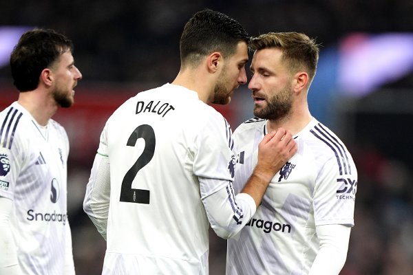 Manchester United's Diogo Dalot speaks with team-mate Luke Shaw (right) during the Premier League match at Villa Park, Birmingham. Picture date: Sunday December 21, 2025.
