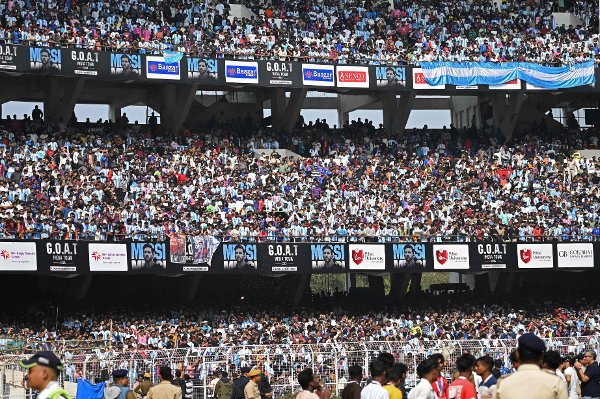 Fans react as Inter Miami's Argentine forward #10 Lionel Messi departs from the Salt Lake Stadium in Kolkata on December 13, 2025. Thousands of fans packed into a stadium in eastern India on December 13 to cheer on Lionel Messi as the football legend unveiled a 21-metre (70-foot) statue of himself. (Photo by Dibyangshu SARKAR / AFP)