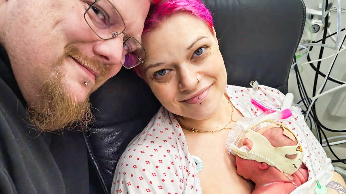 en mann og en kvinne som holder en baby (Bildebeskrivelsen er laget av en KI-tjeneste)