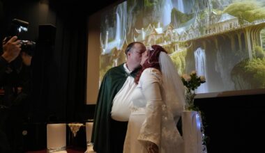 en mann og en kvinne som kysser foran et lerret i en kinosal