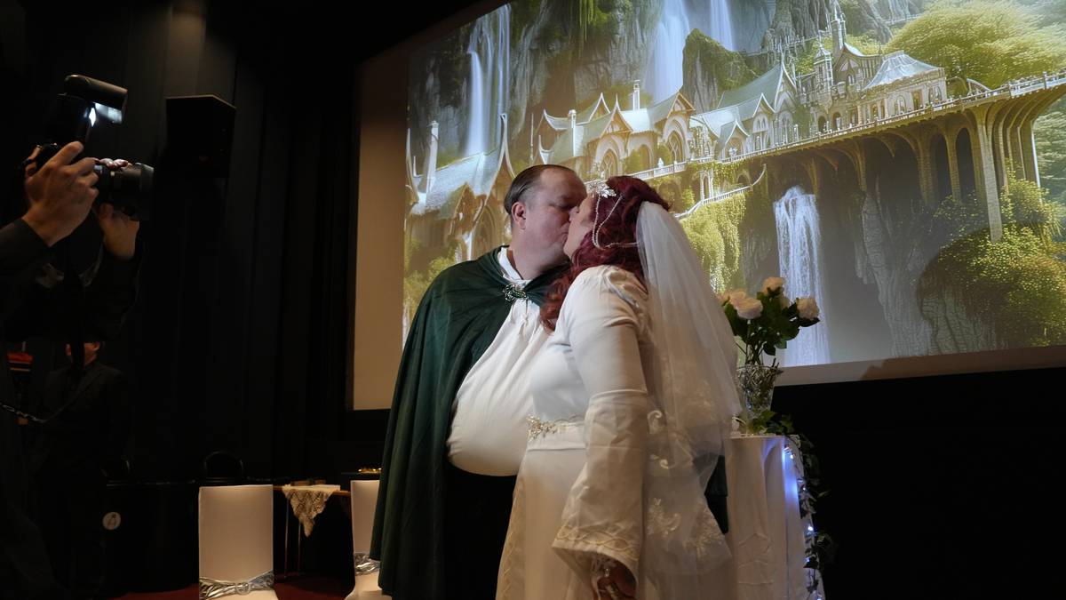 en mann og en kvinne som kysser foran et lerret i en kinosal