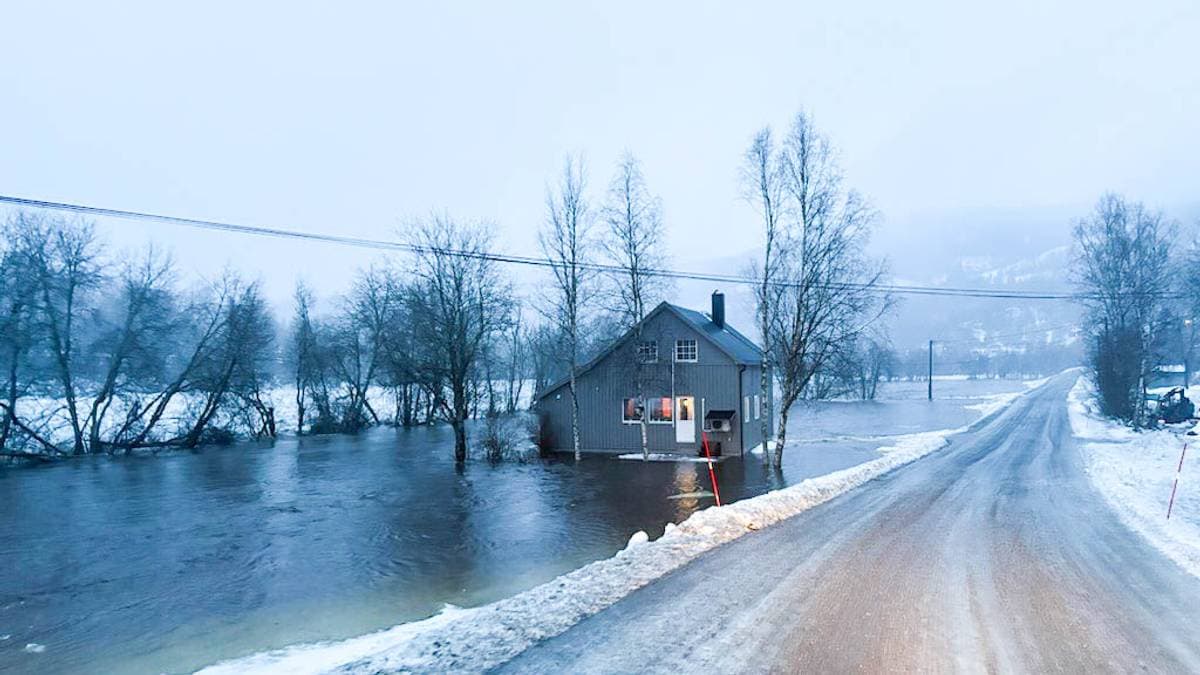 Et hus står i vann etter at Beiarelva har flommet over sine grenser
