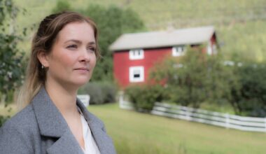 en person som står foran et rødt hus