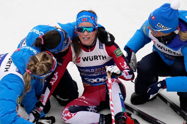 Norway athletes congratulate teammate Kristin Austgulen Fosnaes, center, after she crossed the finish line to win the silver medal in the cross-country women's relay 4X7.5 Km at the Nordic World Ski Championships in Trondheim, Norway, Friday, March 7, 2025. (AP Photo/Matthias Schrader)