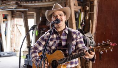 Tobias Sten spiller gitar og synger i mikrofonen. Har på seg en rutete skjorte, cowboyhatt og skjorta ned i buksa.