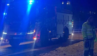 Viser brannbil med blålys og to brannmenn