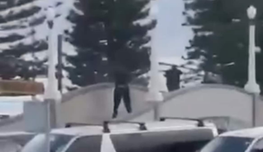 Personer i mørke klær på gangbro