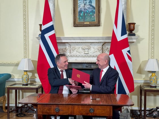 Nores og Storbritannias forsvarsministre tar hverandre i hendene etter avtalesignering.