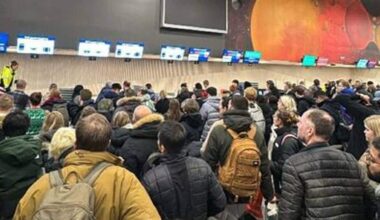 mange mennesker i kø inne på en lufthavn.