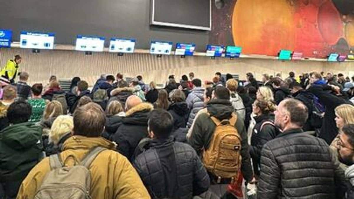 mange mennesker i kø inne på en lufthavn.