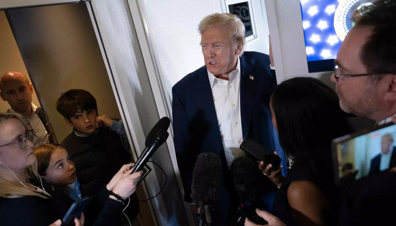 I BAKGRUNNEN: Miller (bak til venstre) følger med når president Donald Trump blir intervjuet om bord på Air Force One. Foto: Brendan Smialowski / AFP / NTB