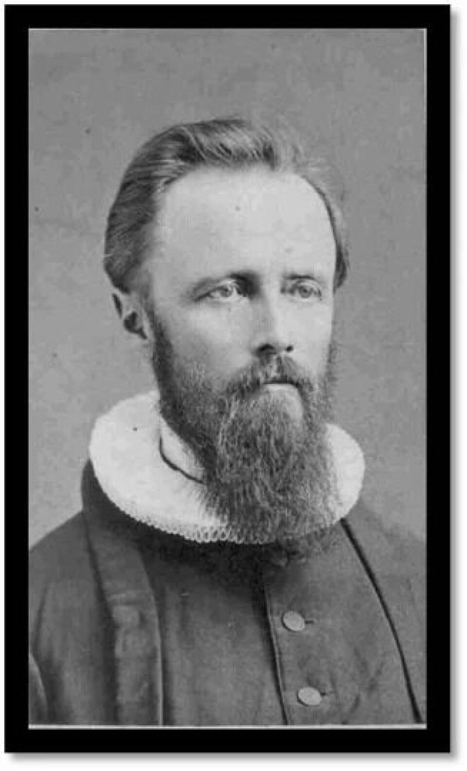 Svart-hvitt portrett av Bernt Muus i prestekjole med pipekrage og skjegg.