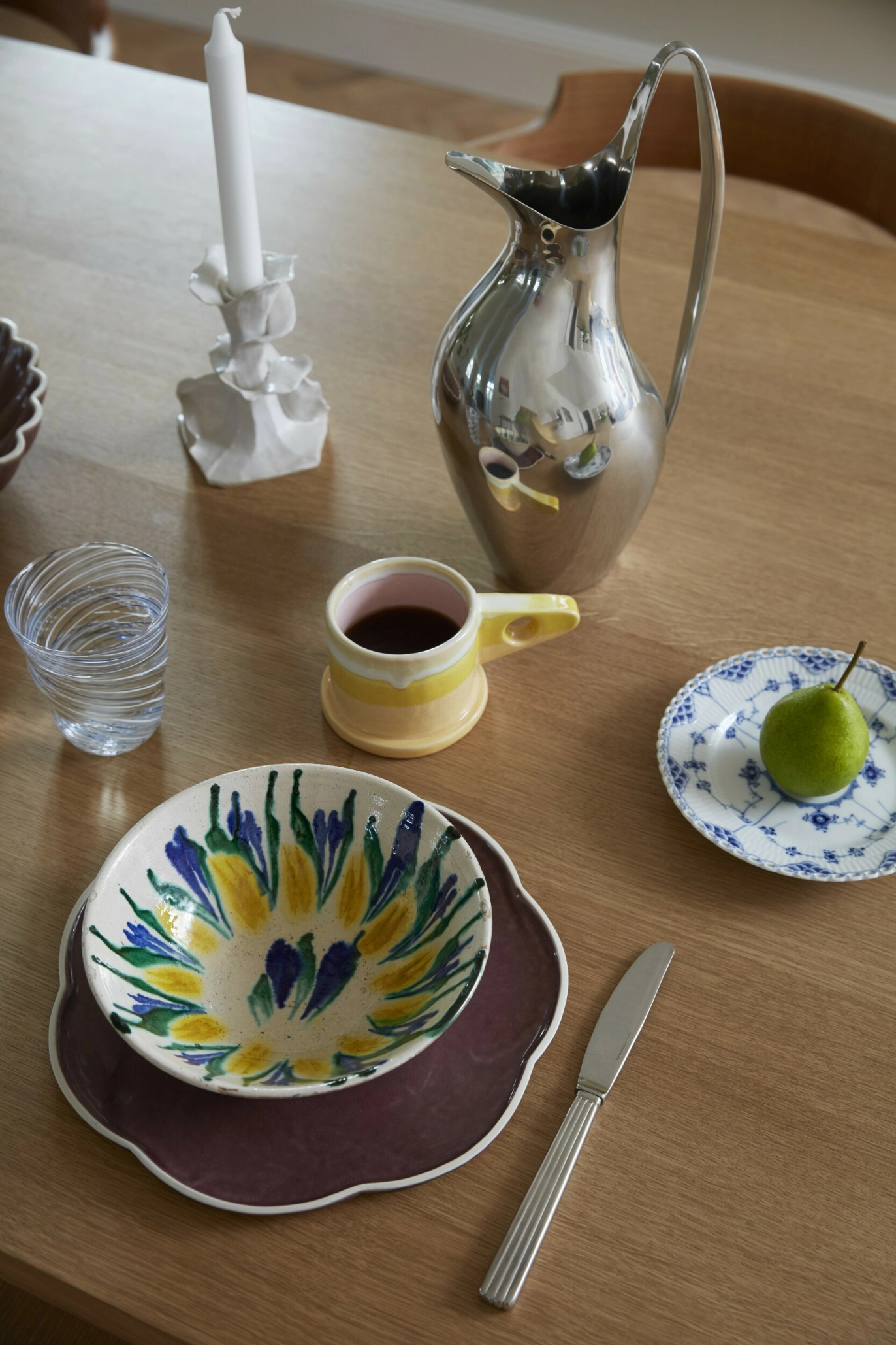 På bordet ser man en miks av teksturer i keramikk, stål
og glass. Keramikk av Hanne Bertelsen, Maria Worsaae
og Peter Shire. Lysestake av Amalie Bønnelycke Lunøe
og kanne fra Georg Jensen. FOTO: Mia Mortensen