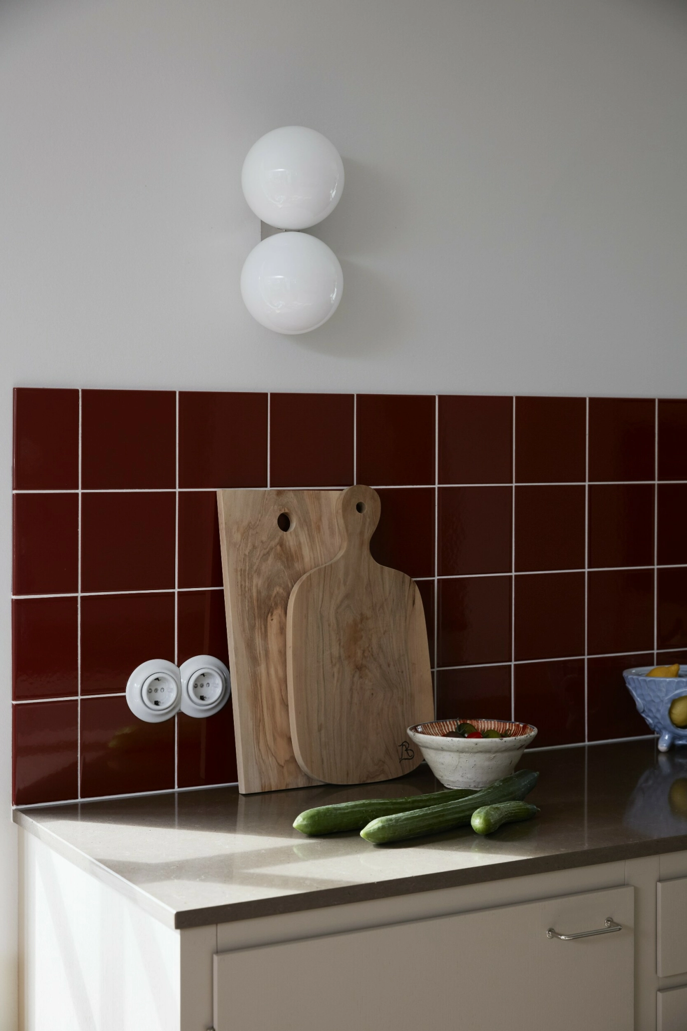 De dype, rødbrune flisene
gir kjøkkenet karakter og
varme, og står i vakker kontrast til de lyse frontene og
skjærefjølene på benken. FOTO: Mia Mortensen