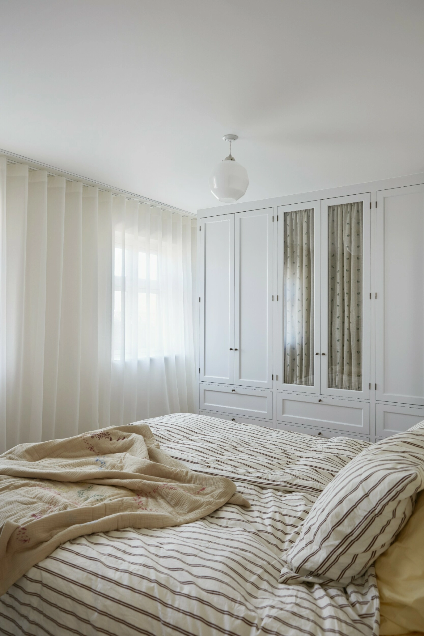 Skapveggen på soverommet er
spesialtegnet til rommet og laget
av en snekker. Stoffgardinet i
skapet er fra Décors Barbares, sengetøyet fra Tekla og sengeteppet
av Helle Skaarup. Gardinene er en
blanding av lin og silke fra Helene
Blanche. Skapet er malt i fargen
«Meg White» fra File Under Pop. FOTO: Mia Mortensen