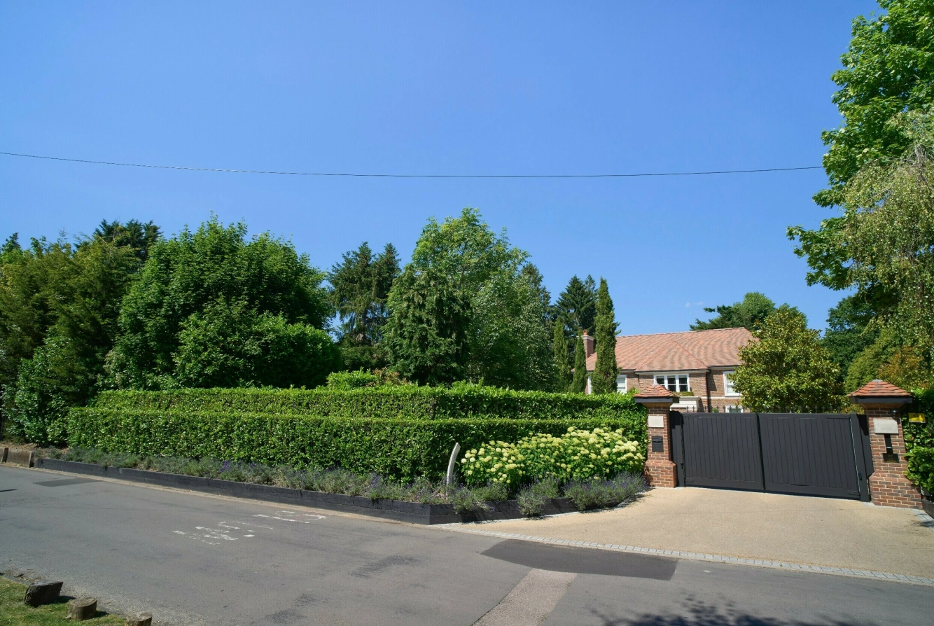 HER BOR DE: Skjermet av hekkerog murer ligger familiens hjem i et eksklusivt strøk i en søvnig landsby utenfor London. Foto: Peter van den Berg