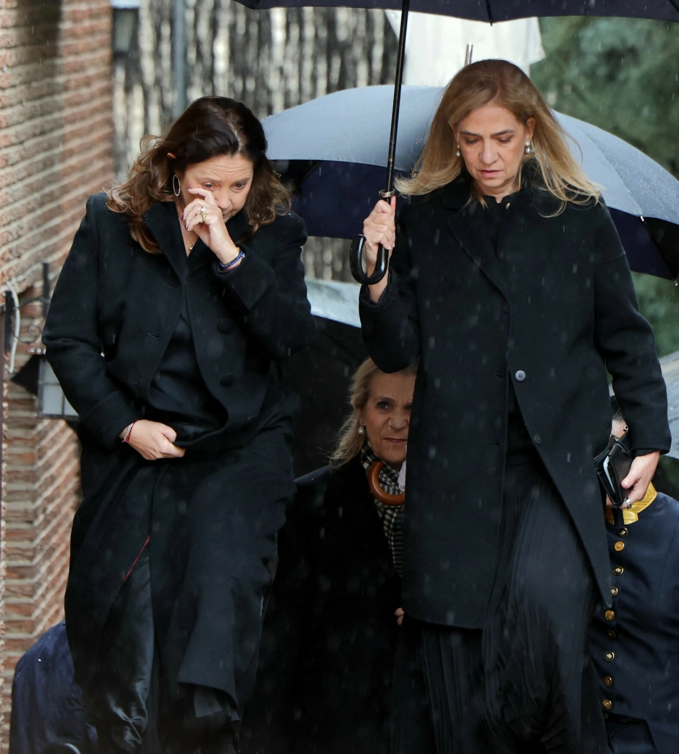 KUSINER: Prinsesse Alexia var tydelig preget på vei inn til seremonien. her sammen med kusinen Cristina, mens Elena kan sees i bakgrunnen. Foto: Thomas Coex / AFP / NTB