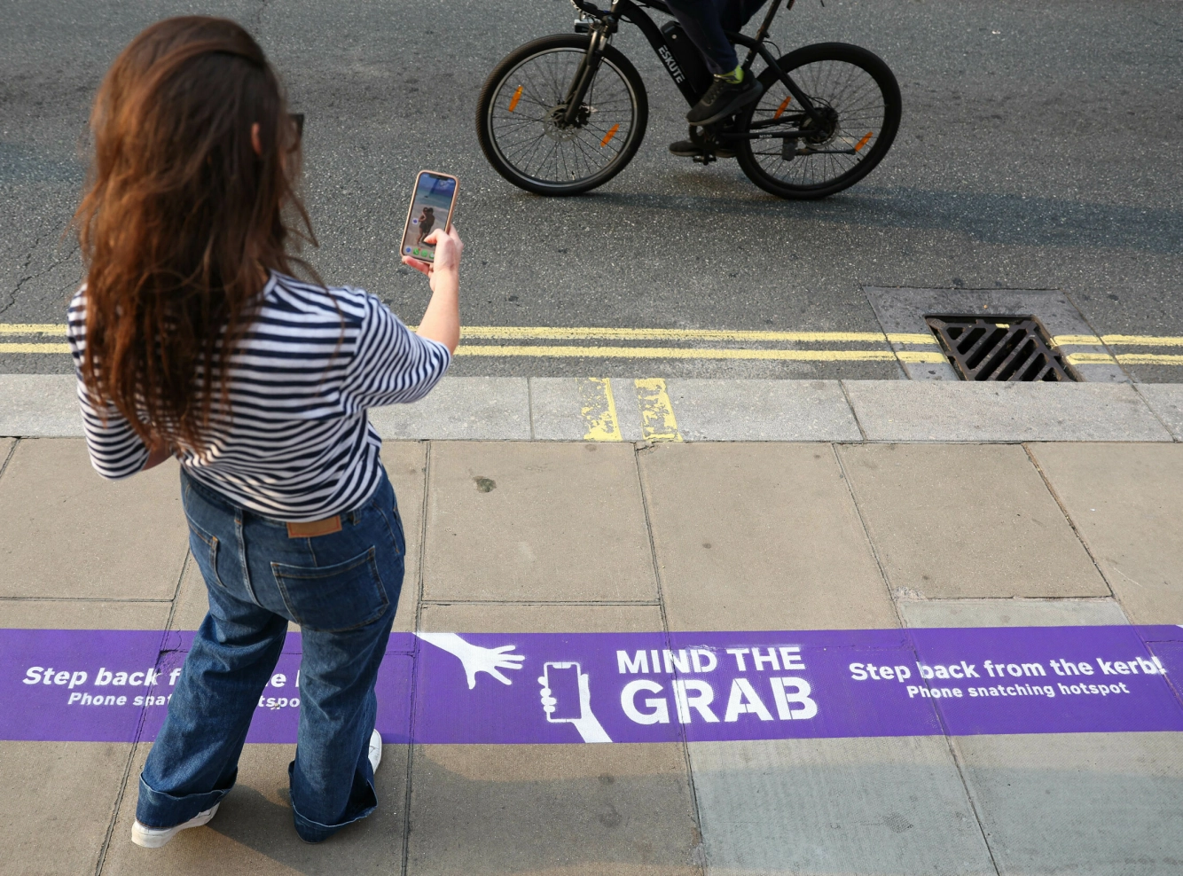MIND THE GRAB: En av butikkene i Oxford Street vakte oppsikt i fjor da de installerte denne beskjeden på bakken. Målet var å gjøre folk oppmerkomme på tyveriene. Foto: Kieran Cleeves Media Assignments/NTB