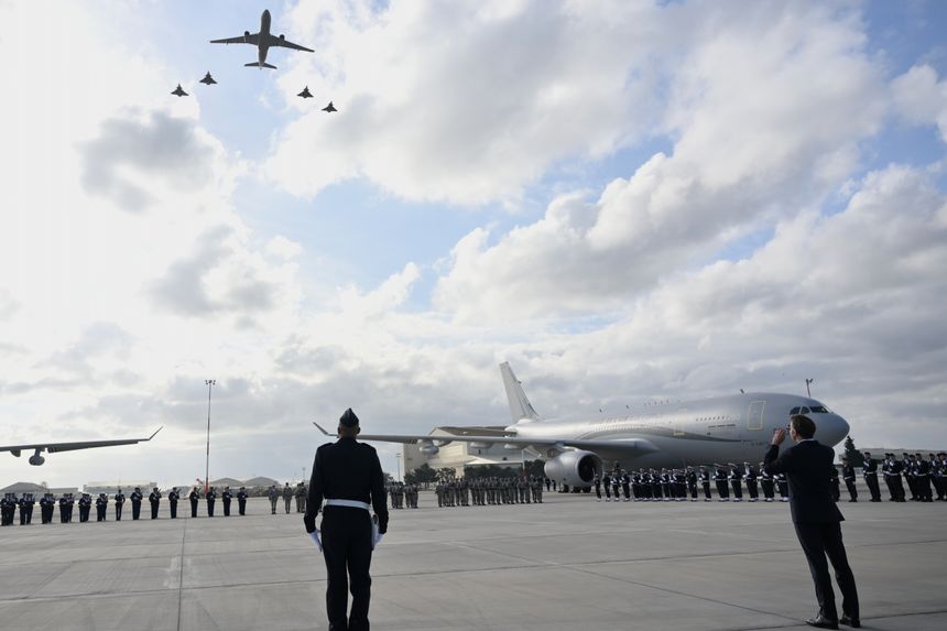Macron (t.h.) ser opp mens militærfly flyr over Istres-flybasen torsdag denne uken. Foto: Philippe Magoni/AP/NTB