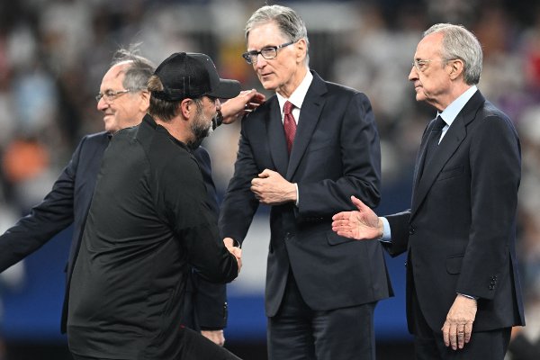 Liverpool's German manager Jurgen Klopp (L) shakes hands with Liverpool's US owner John W. Henry (C) standing next to Real Madrid's president Florentino Perez (R) during the medal ceremony at the end of the UEFA Champions League final football match between Liverpool and Real Madrid at the Stade de France in Saint-Denis, north of Paris, on May 28, 2022. - Real Madrid claimed a 14th European Cup after beating Liverpool 1-0 in the Champions League final at the Stade de France, in France. (Photo by Paul ELLIS / AFP)