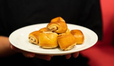 Et fat med kanelgifflar blir holdt opp.