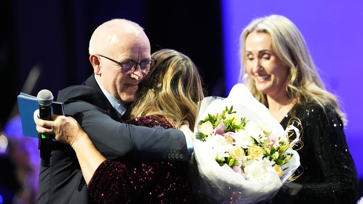 En mann og en kvinne som holder blomster (Bildebeskrivelsen er laget av en KI-tjeneste)