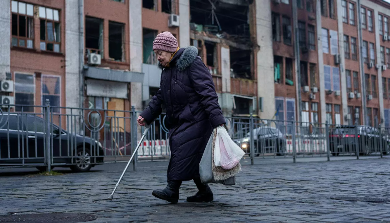 En eldre kvinne foran en ødelagt bygning i Kyiv. Bildet ble tatt 1. desember. Foto: Jevhen Maloletka / AP / NTB